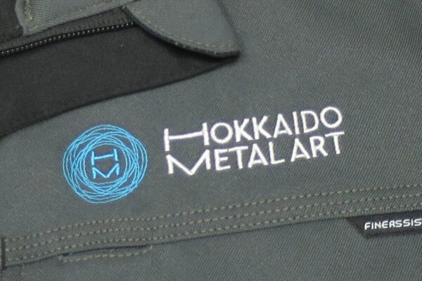 作業ブルゾンの左胸に繊細なデザインの企業ロゴ刺繍