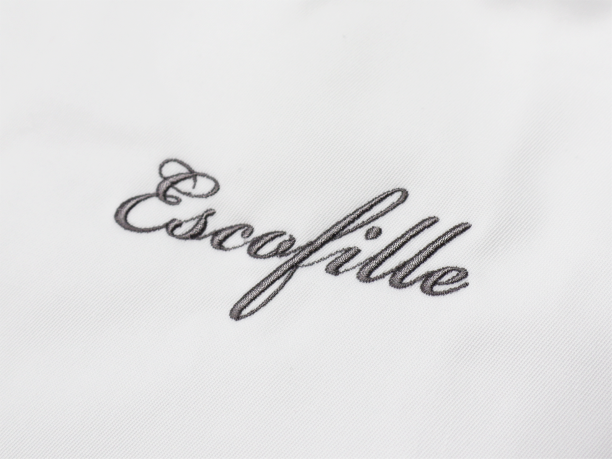 コックコートの胸元に筆記体でネーム刺繍を入れた飲食店ユニフォームの制作実績