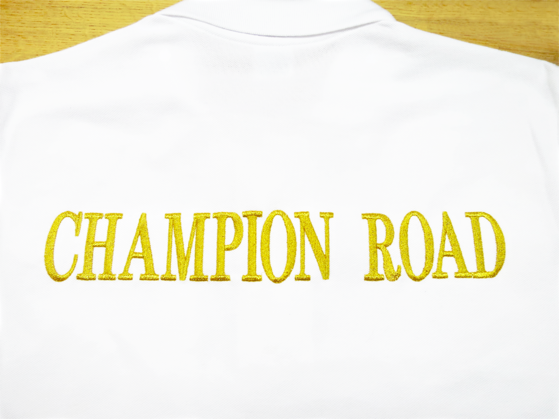 ポロシャツ背中文字入れ刺繍制作実績｜金糸による存在感あるロゴ表現