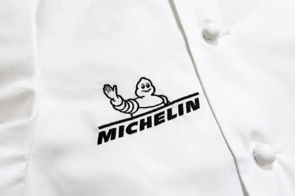 ドラマ撮影用の白いシェフコートにMICHELINロゴを刺繍した制作事例。コックコート胸元への企業ロゴ刺繍。