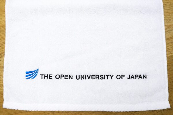 放送大学様ロゴを刺繍した白地ハンドタオル｜学校法人・教育機関向けオリジナル刺繍記念品