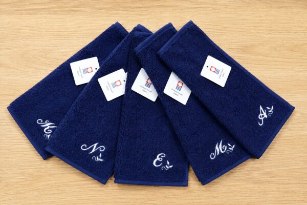 今治ロゴ付きネイビーの今治ハンドタオルにイニシャル刺繍とオリジナル花刺繍を施した卒業記念品実績