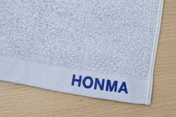 HONMAの名入れ刺繍を施したグレーの今治タオル。お中元・お歳暮・法人ギフト向けオリジナル刺繍制作事例。
