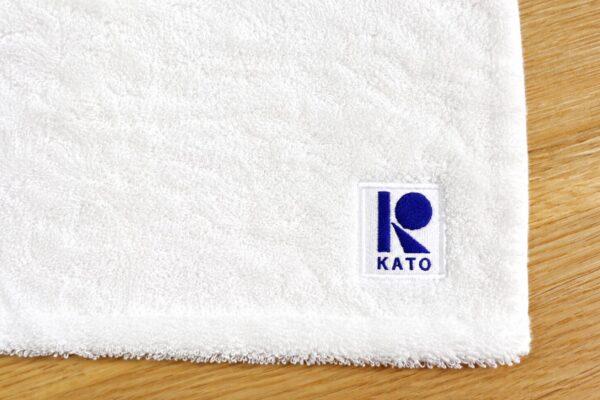 ホワイト色の今治タオルに企業ロゴを刺繍した販促品向けオリジナルタオル