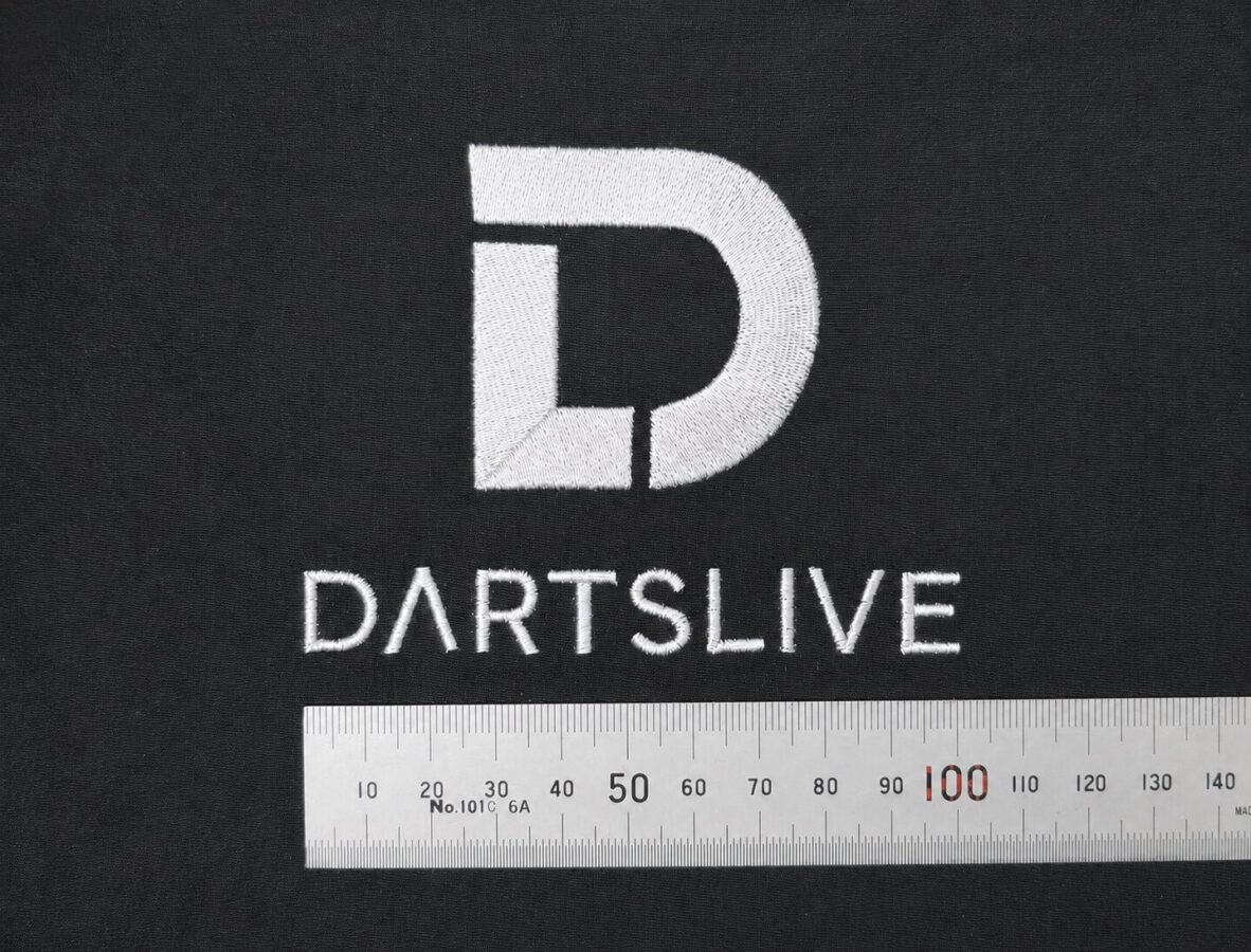 黒色の持ち込み布地に、白糸でシンボルマークと「DARTSLIVE」の文字を刺繍したオリジナルロゴ刺繍例