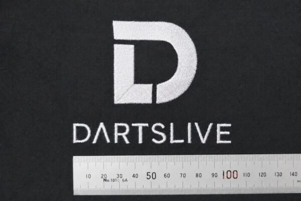 黒色の持ち込み布地に、白糸でシンボルマークと「DARTSLIVE」の文字を刺繍したオリジナルロゴ刺繍例