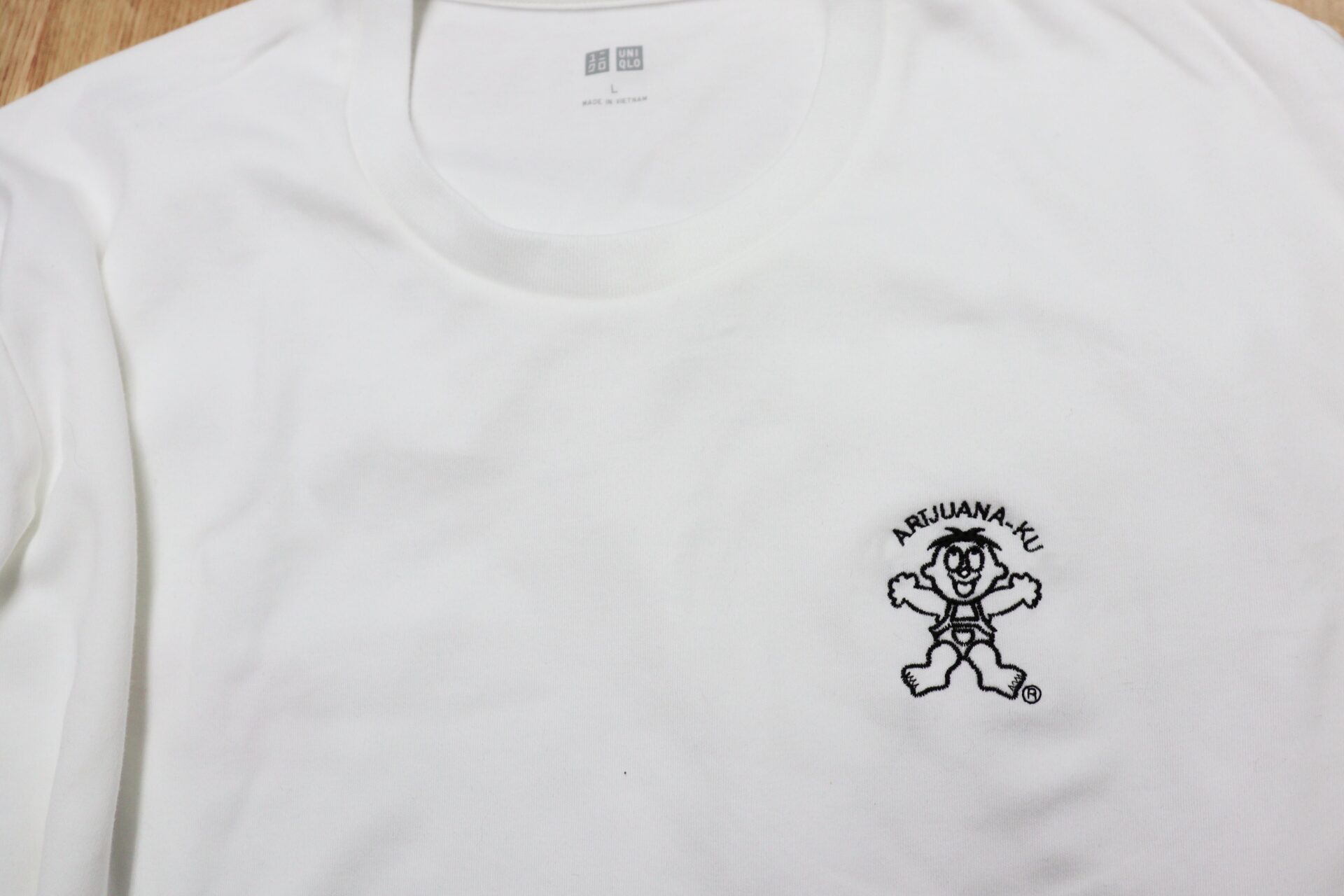 白いTシャツの胸元へオリジナルデザイン刺繍|細かな文字とキャラクターを黒糸で表現